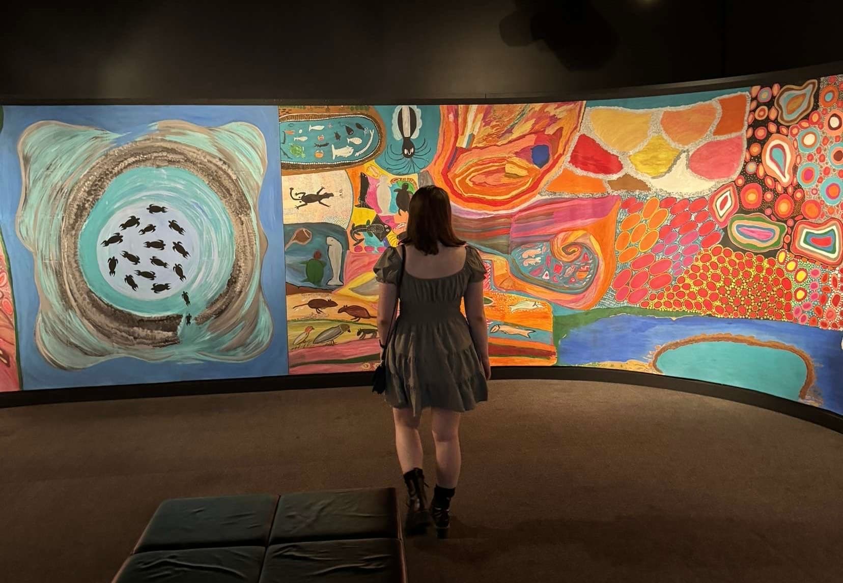 Lily standing in front of colourful artwork